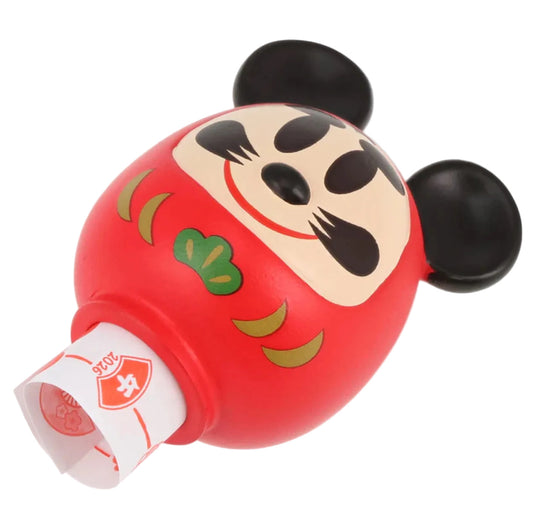 Red character-shaped container with a white label on a light gray background