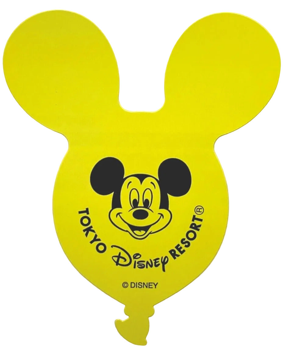 Yellow mouse ear hat with Mickey Mouse face and 'Tokyo Disney Resort' text on a beige background