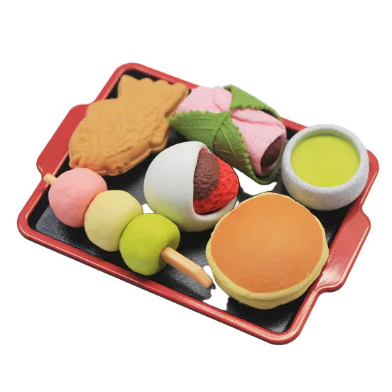 Colorful toy food set on a black tray with a red border